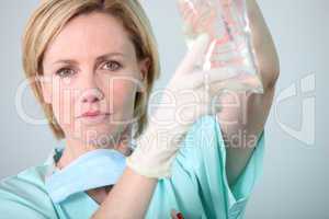 Hospital nurse attending to a drip bag