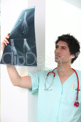 Male nurse holding up x-ray image