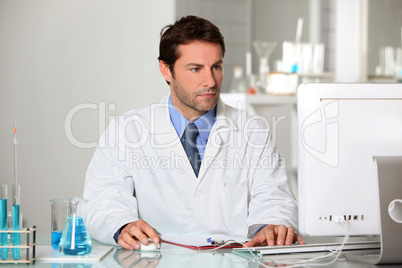 Lab technician studying test results on a computer