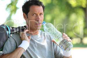 man in sports clothes drinking water