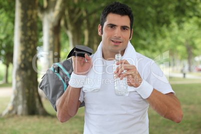 Man drinking water after a run in the park