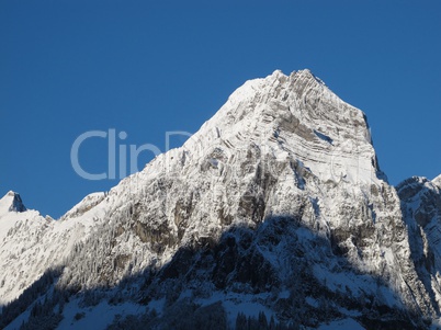 Snow Capped Mountain Peak With Visible Rock Layers