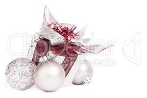 silbernes weihnachtsgeschenk mit roten schleifen und christbaumkugeln