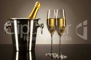 zwei gläser mit champagner mit einer flasche sekt in einem kühler