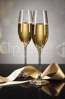 zwei gläser champagner mit goldenem band