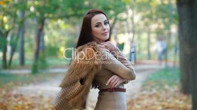 Young Woman Wearing Fur Vest in the Autumn Park