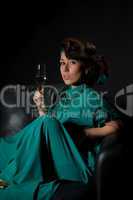 Beautiful girl sitting on a sofa with glass of wine