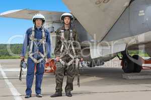 Two military pilot in a helmet near the aircraft