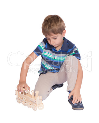 Boy playing with a toy train. Isolated over white background.