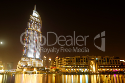 Buildings in Dubai Downtown and man-made lake in night illuminat