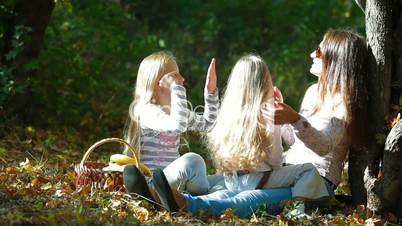 Happy Mother and Daughters Playing Outdoors
