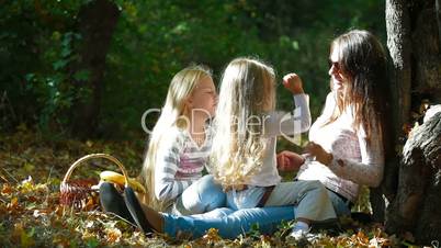 Happy Mother and Daughters Laughing In The Park