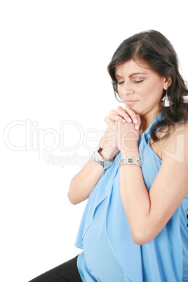 Hispanic pregnant woman praying with hands together