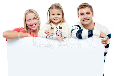 Smiling family with whiteboard in a studio