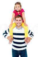 Fun loving kid sitting on her father's shoulders