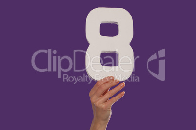 Female hand holding up the number 8  from the top