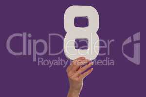 Female hand holding up the number 8  from the top