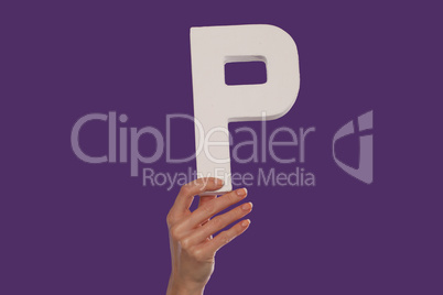 Female hand holding up the letter P from the bottom
