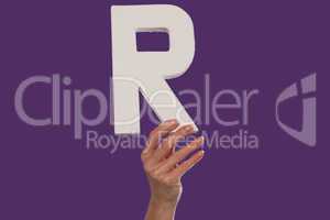 Female hand holding up the letter R from the bottom