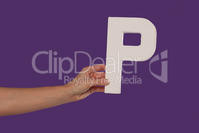 Female hand holding up the letter P from the left