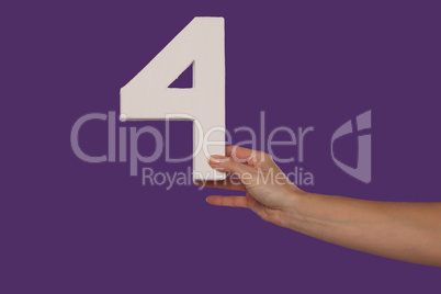 Female hand holding up the number 4 from the right