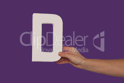 Female hand holding up the letter D from the right