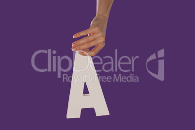 Female hand holding up the letter A from top