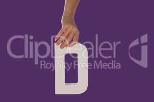 Female hand holding up the letter D from top