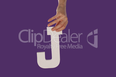 Female hand holding up the letter J from top