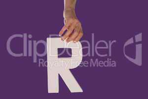 Female hand holding up the letter R from top