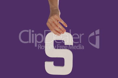 Female hand holding up the letter S from top