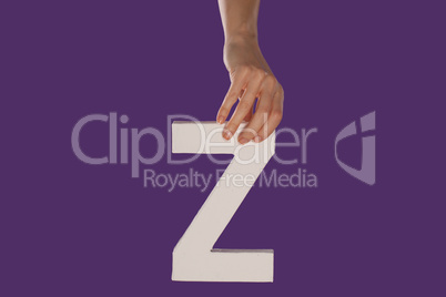Female hand holding up the letter Z from top