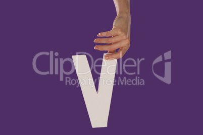 Female hand holding up the letter v from top