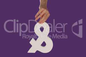 Female hand holding up an ampersand from the top
