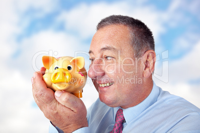 Businessman is pleased with his piggy bank