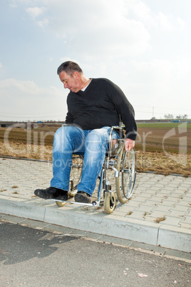 Man with a wheelchair on road pavement