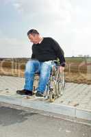 Man with a wheelchair on road pavement