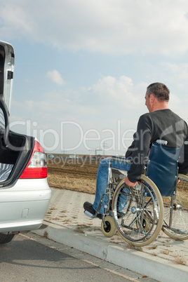 Man in a wheelchair next to his car