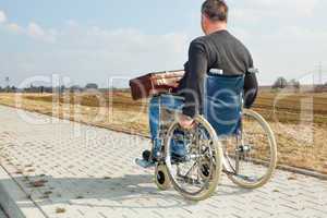 Man with suitcase wheelchair and walk on the road