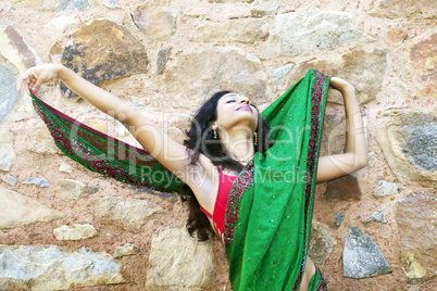 indische Frau in einem Saree an einer Steinwand