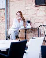 junge frau trinkt kaffee auf einer Terrasse in einem Restaurant