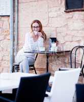 junge frau trinkt kaffee auf einer Terrasse in einem Restaurant