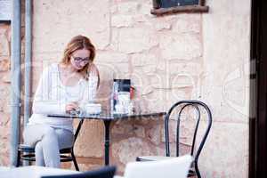 junge frau trinkt kaffee auf einer Terrasse in einem Restaurant