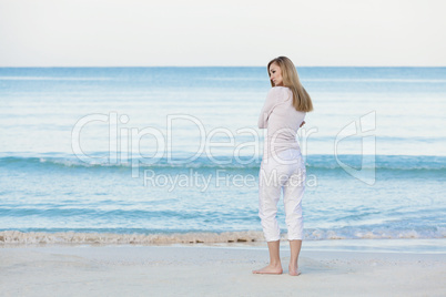 Hübsche blonde junge frau entspannt sich alleine am Strand am m