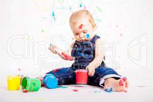 kleines junges baby malt mit Farben und pinsel