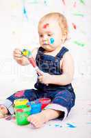 kleines junges baby malt mit Farben und pinsel
