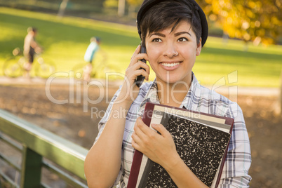 Mixed Race Female Student Holding Books and Talking on Phone