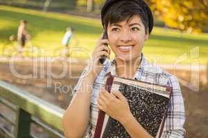 Mixed Race Female Student Holding Books and Talking on Phone