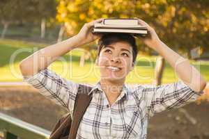 Mixed Race Female Student Holding Books on Her Head