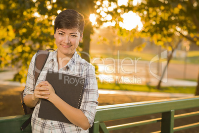 Portrait of a Pretty Mixed Race Female Student Holding Books